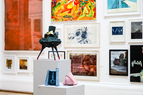 RWA 167 Annual Open Exhibition, installation view. Three sculptures are displayed on plinths in the RWA gallery space, behind on the wall are several brightly coloured art works exhibited.